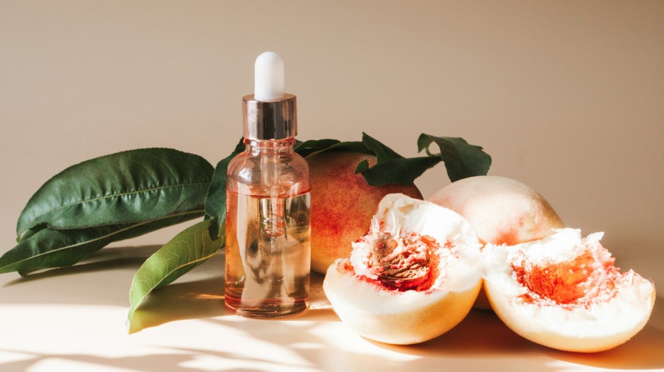A bottle of lotion sitting next to some fruit